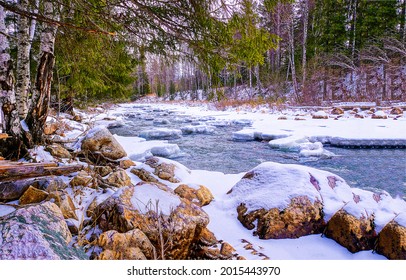 Rocky river bank in the snow. Winter forest river snow. Snowy river in winter forest. Winter forest river snow