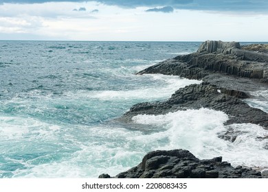 rocky seashore formed by columnar basalt against the backdrop of a stormy sea, coastal landscape of the Kuril Islands - Shutterstock ID 2208083435