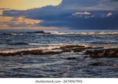 Rocky Seashore with Waves and Dramatic Cloudy Sky at Sunset