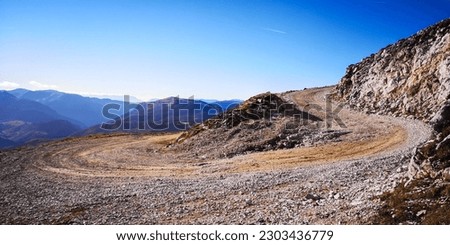 Rocky serpentine path on a mountain road with blue sky