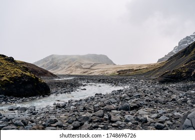 Rocky shallow mountain river in Iceland, flows against the backdrop of mountains. - Powered by Shutterstock