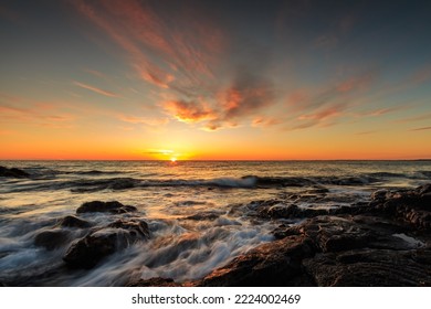 Rocky shore of the Atlantic Ocean at high tide at sunset