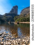 A rocky shore on the nine bend river or Jiuxi in Wuyishan or Mount Wuyi scenic area in Wuyi China in Fujian province. Deep blue sky, vertical picture with copy space for text