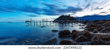 Rocky shore on Pacific Ocean West Coast. Nature Background. Sunset Sky. Whytecliff Park, West Vancouver, BC, Canada.