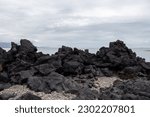 A rocky shore of South Iceland beach with black volcanic rocks in the Iceland South coast