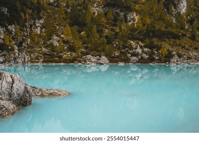 A rocky shoreline with a body of water that is blue in color lake sorapis dolomites - Powered by Shutterstock