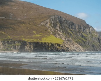 A rocky shoreline with a cliff in the background. The water is choppy and the sky is clear. Achill island area, Ireland. Nobody. Stunning wild Irish nature scene. Warm sunny day, blue sky. - Powered by Shutterstock