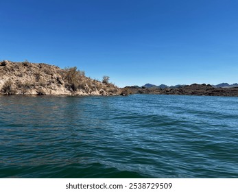 Rocky Shoreline of Desert Lake Under Clear Blue Sky - Powered by Shutterstock