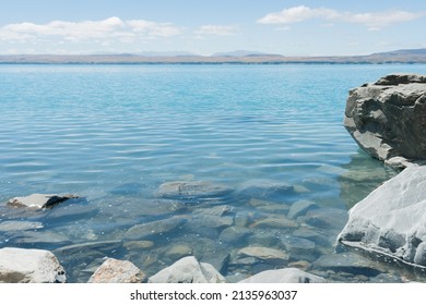 Rocky Shoreline Of Lake Pukaki Turquoise Water In Canterbury, South Island NZ.