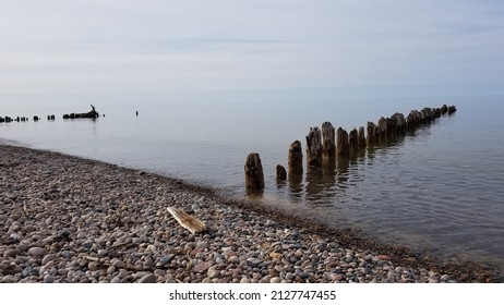 A Rocky Shoreline Of Lake Superior With The Old Remains Of An Eroded Dock.