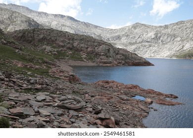 Rocky shoreline of a mountain lake in the Pyrenees, part of the Porta del Cel trail. Beautiful untouched nature, perfect for outdoor and adventure enthusiasts. - Powered by Shutterstock