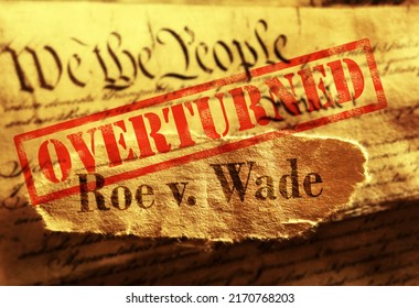 Roe V Wade newspaper headline with red Overturned stamp on the United States Constitution                               