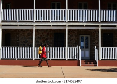 ROEBOURNE, WA - JUNE 6 2022:Australian Aboriginal Men Passing By Victoria Hotel Building That Once Was A Notorious Alcohol Abuse Pub Turned To A Proud Indigenous Community Cultural Centre Of Roebourne