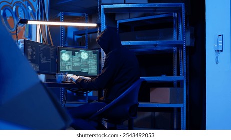 Rogue computer expert in graffiti sprayed hideaway targeting vulnerable unpatched connections, focused on getting past digital devices security and stealing valuable sensitive data, dolly in shot