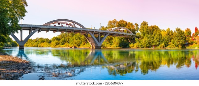 Rogue River Bridge, spanning Redwood Highway 25 in Grants Pass, Josephine County, Oregon. The arching bridge reflected on Rogue River at sunset. - Shutterstock ID 2206604877