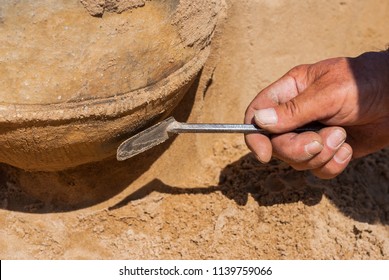 ROKYTNO, CZECH REPUBLIC - JULY 5, 2018: Archeologist cleans urn at the archeological site of the bronze age cemetery near Pardubice, Czech rep. Urns date back to lusatian culture (1300 BC – 500 BC).