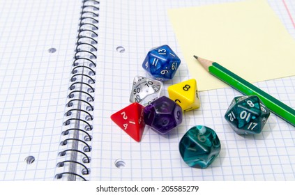 Role Playing Dices Lying On Exercise Book - Stock Photo