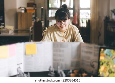 Role Playing Tabletop And Board Games Hobby Concept. Young Adult Asian Woman Enjoying With Storytelling. Blur Foreground With Dungeon Master Screen And Monster Miniatures.