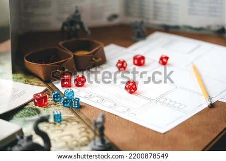 Role playing tabletop and board games hobby concept. D20 dice place on character sheets for create begin fantasy and adventure. Background with book and miniatures.