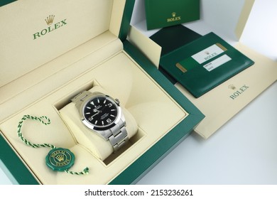 Rolex wristwatch explorer I model is inside the green leather box of Rolex wristwatch which is on white table with service book and serial number card in authorized dealer Rolex shop