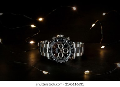 Rolex wristwatch model cosmograph daytona oyster perpetual superlative chronometer with black ceramic bezel stainless steel body on black table with black wall led light in authorized dealer shop