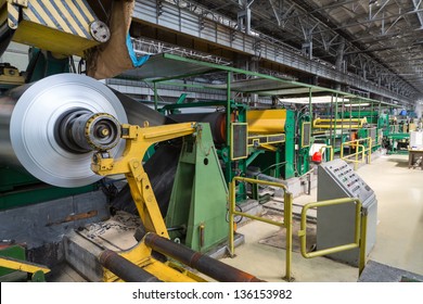 Roll of aluminum rotates on machine in workshop on rolling mill - Powered by Shutterstock