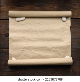 Roll Of Brown Kraft Paper On A Wooden Background. Place For An Inscription