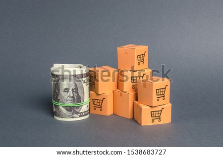 Roll bundle of dollars and cardboard boxes. International trade and trading balance. Global market and business, import and export of goods and services. Fees and trade wars. Economics and GDP.