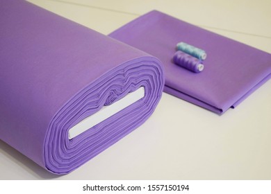 Roll Of Cotton Natural Fabric, Purple - On A White Table