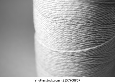 Roll Of A Cotton Twine With Blurred Light Grey Background. Focused Reel Of Yarn Thread.