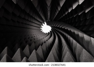 Roll of dark gray triangular acoustic foam rubber and light hole. The pattern of the soundproof panel of polyurethane foam. Shockproof foam. Selective focus.	