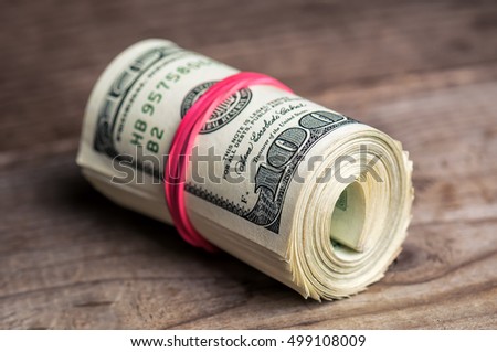 roll of dollars with red rubber