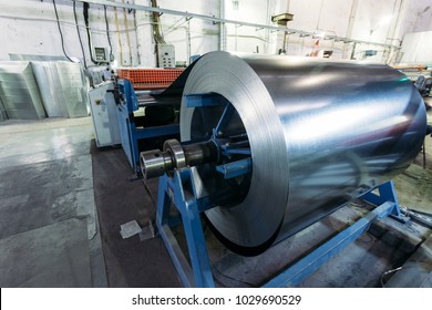 Roll Of Galvanized Steel Sheet Feeds Steel Sheets To The Cutting Machine For Manufacturing Metal Pipes And Tubes In The Factory