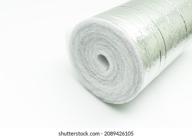 A roll of insulation made of foamed polyethylene with aluminum foil. Thermal insulation with reflective foil. Selective focus, copy space
