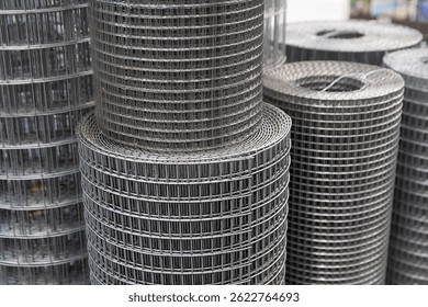 Roll of metal mesh with rectangular cells on the window of a construction store. Industry