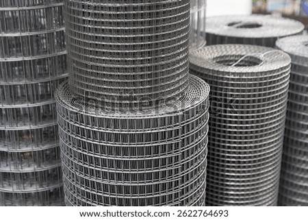 Roll of metal mesh with rectangular cells on the window of a construction store. Industry