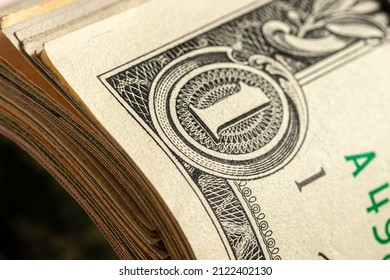 A roll of money tightened by an elastic band close-up macro shot. Usd money wad, bundle of usa cash. Several American dollar bills rolled and tied up. One dollar bill. - Shutterstock ID 2122402130