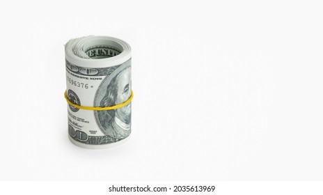 Roll Of Money Wrapped In Yellow Elastic Band Isolated On White Background. US Dollar Banknote. Copy Space