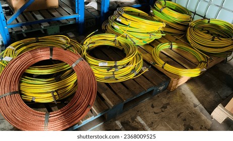 a roll of new 50mm BC and 50mm BCC grounding yellow green coated copper wire from the factory, stored in the warehouse to be distributed to site locations for lightning protection.