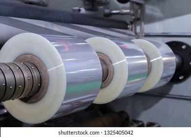 Roll Of Plastic Packaging Film On The Automatic Packing Machine In Food Product Factory. Industrial And Technology Concept.