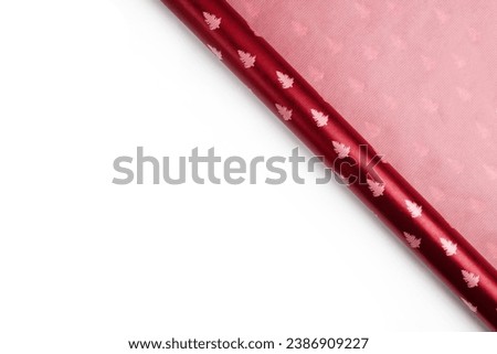 Roll of red christmas wrapping paper isolated on white background. New Year card, top view, copy space