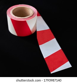 Roll Of Red And White Caution Tape Against A Dark Background, Shallow Depth Of Sharpness