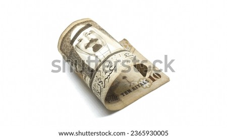 A roll of Saudi Arabian banknotes worth ten riyals. Saudi Arabian currency isolated on white background