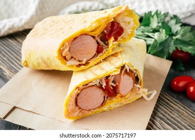 Roll With Sausages And Vegetables. Hot Dog In Pita Bread On Craft Paper On Wooden Dark Background With Cherry Tomatoes And Green Parsley