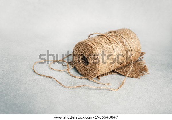 Roll of\
sisal rope isolated on light gray\
background.