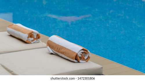 Roll Soft Towel On A Sun Bed Near A Swimming Pool.