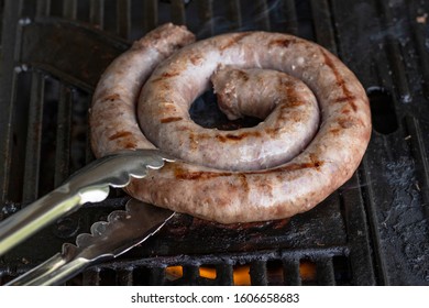 A Roll Of South African Sausage Cooking On A Gas Bbq.