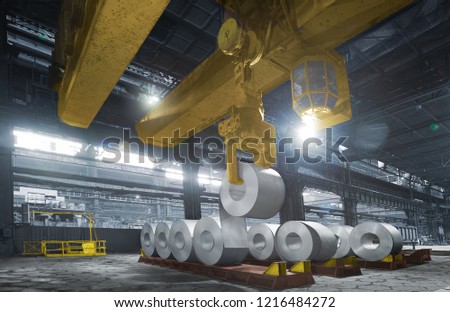 Roll of steel sheet in a plant, picjked up by crane
