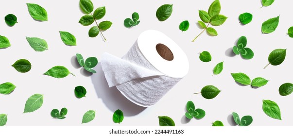 A roll of toilet paper with green leaves - flat lay - Shutterstock ID 2244491163