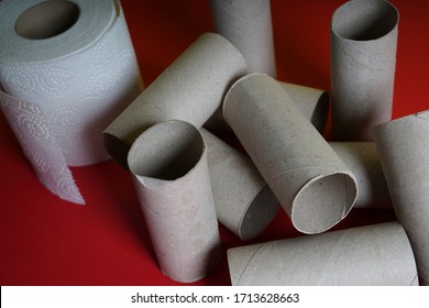 A Roll Of Toilet Paper Next To An Empty Roll Of Toilet Paper On A Red Shelf. Close Up Viewed From Above